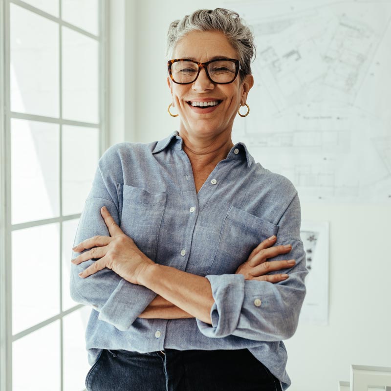 Successful senior architect standing in her office with crossed arms