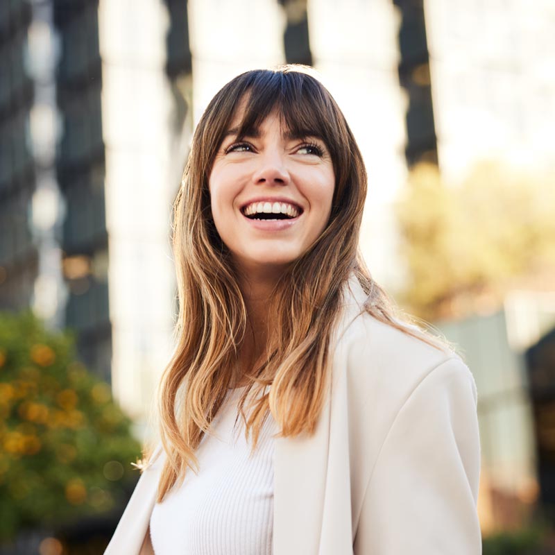 young professional strolls, casting a glance back with a broad and genuine smile