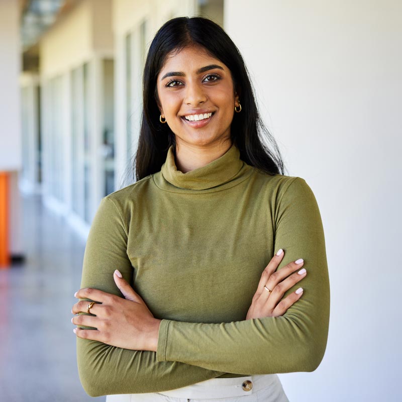 Smiling young businesswoman standing in the corridor of an office