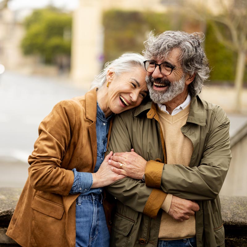 Cheerful mature pair smiling and embracing