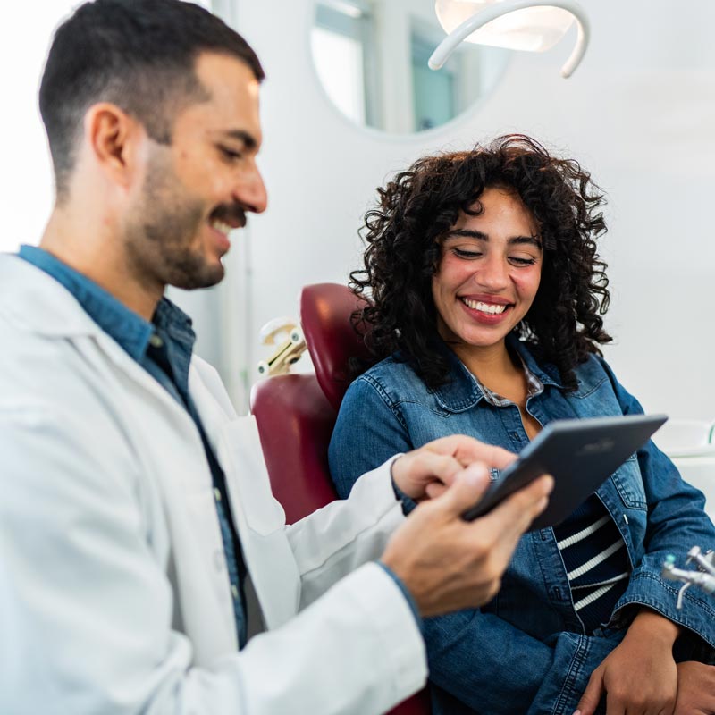 dentist showing patient images on tablet