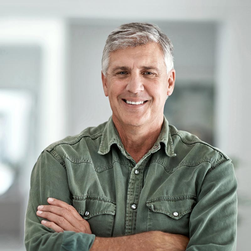 Portrait of a mature man standing with his arms crossed at home